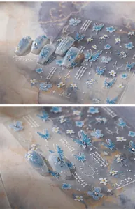 Detail of 5D embossed blue butterfly and flower nail stickers with pearl chain accents