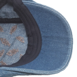 Close-up of denim newsboy hat interior showing fishbone print lining and sweatband