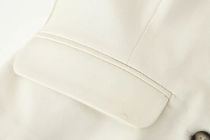 Detailed macro view of beige vest pocket showing twill fabric texture and clean stitching