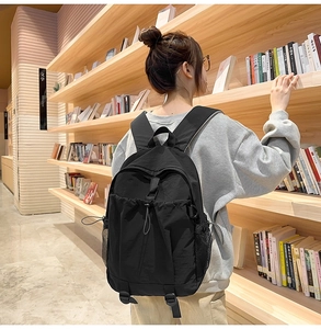 Schwarzer Nylon-Rucksack mit seitlichen Netztaschen und verstellbaren Trägern in einer Bibliothek