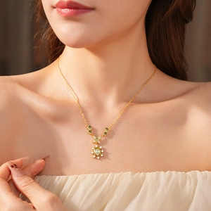 Gros plan détaillé d'un collier vintage doré avec pendentif tournesol en zircon vert ovale