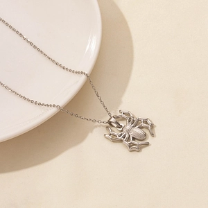 Detail of silver spider pendant with intricate grid texture on a stainless steel chain