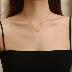 Elegant gold titanium necklace featuring a square four-leaf clover pendant with diamonds
