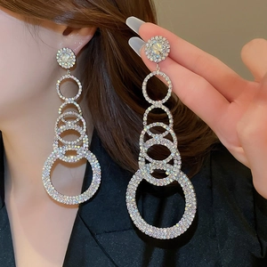 Detail of luxury silver fringe earrings with sparkling colorful rhinestones on model