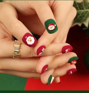 Close-up detail of matte Christmas press-on nails with festive Santa Claus 3D charms