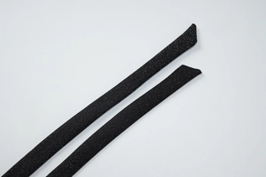 Détail rapproché de sangles en tissu noir pailleté avec une texture fine et scintillante