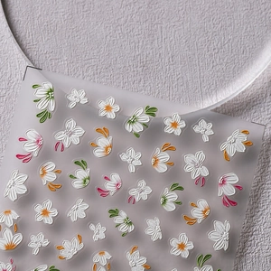 Adesivi per unghie camelia bianca 3D con foglie verdi su supporto smerigliato