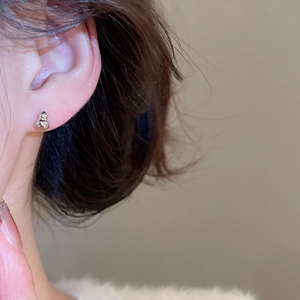Gros plan d'un mannequin portant des boucles d'oreilles gourde en argent et zircon