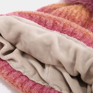 Detailed close-up of pink-orange gradient knit hat with thick beige fleece lining for warmth