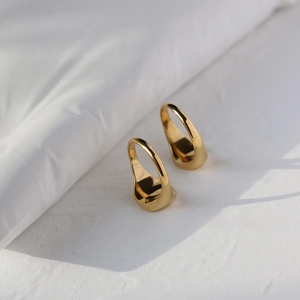 Macro shot of minimalist gold teardrop ring set with a mirror polished 18K gold finish