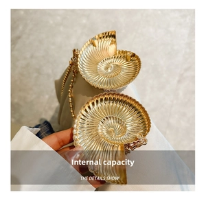 Detail view of the open golden shell clutch bag with internal space and beaded chain strap