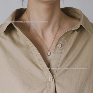 Detail of 18K gold plated starburst necklace with white mother of pearl rectangle pendant