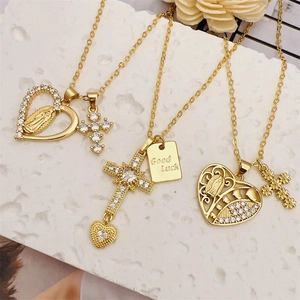 Close-up of 18K gold plated necklaces featuring Virgin Mary heart and Good Luck charms