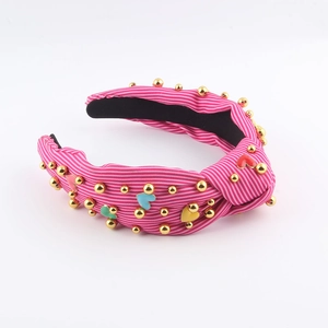 Detailed shot of striped fabric headband with colored enamel hearts and gold beads