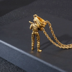 Detailed view of a gold soldier pendant on a twisted rope chain over a black surface