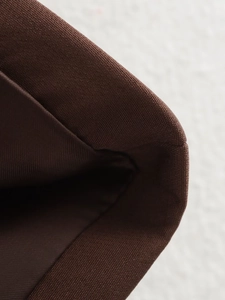 Detailed macro view of the brown canvas fabric texture and fine stitching on the suit