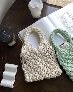 Close-up of handmade woven tote bag with internal drawstring pouch on a wooden desk