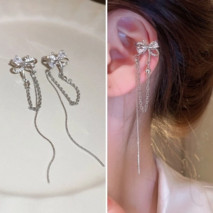 Détails de boucles d'oreilles à nœud argentées avec zircons sur modèle et à plat