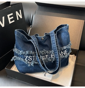 Détail d'un grand sac cabas en jean avec broderie 7STREET dans un coffret cadeau noir