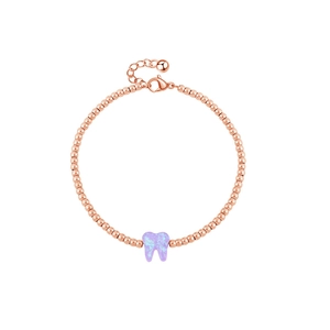 Dettaglio del bracciale con perline in oro rosa e ciondolo a forma di dente lavanda