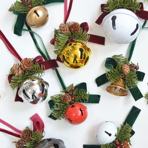 Christmas bell ornaments set with pine cones berries and velvet ribbons on white background