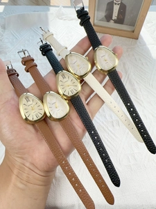 Detailed close-up of multiple vintage-style oval watches with leather straps and gold cases