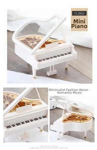 Macro view of white miniature piano music box featuring gold pedals and Piano Recital text