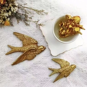 Three gold swallow wall decor pieces and angel statue in vintage luxury style