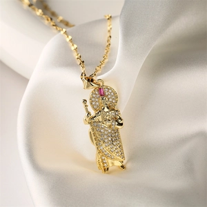 Macro detail of 18K gold plated pendant with sparkling zircons and a red gemstone accent