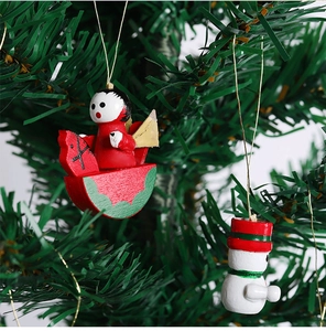 Detail of handcrafted wooden rocking horse and snowman ornaments on green tree needles