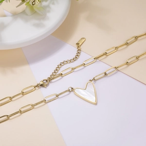 Detail of gold titanium heart necklace with white mother-of-pearl and paperclip chain