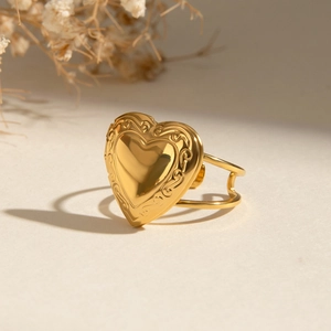 Vintage heart shaped gold plated ring with ornate floral engravings in artistic setting