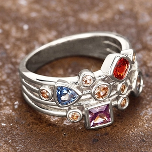 Vista macro de anillo geométrico con gemas de colores y banda ancha con ranuras