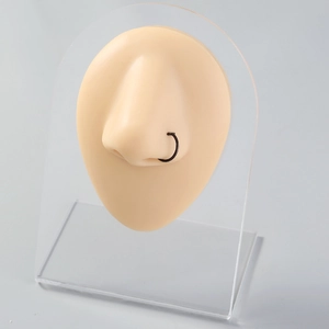 Close-up of a black stainless steel U-shaped nose ring on a realistic silicone nose model