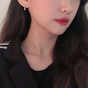 Minimalist silver teardrop stud earrings worn by model showing style and scale