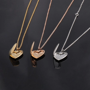 Three open heart-shaped locket necklaces in gold, rose gold, and silver finishes