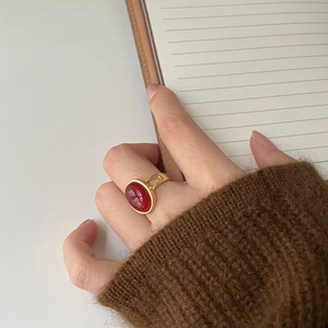 Dettaglio dell'anello in argento 925 con agata rossa su una fascia dorata lucidata