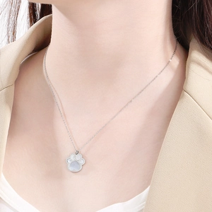 Detail shot of a silver cat paw pendant necklace with a shimmering mother-of-pearl inlay