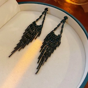 Macro shot of elegant black fringe drop earrings with crystals in a jewelry box