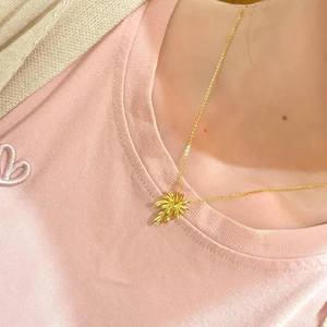 Elegant gold plated palm tree pendant necklace displayed on a model for a chic look