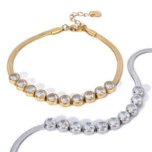 Flat lay of gold and silver snake bone chain bracelets with sparkling round zircon stones