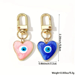 Detailed view of pink and blue heart evil eye keychains with dimensions and weight