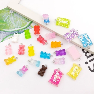 Close-up of colorful resin gummy bear and candy pendants with metal rings for DIY jewelry