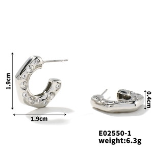 Macro shot of silver C-shape earrings with zircon inlay detailing size measurements