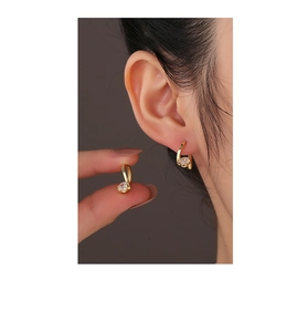 Detail of 14K gold plated S925 silver U-shaped earrings featuring round cubic zirconia