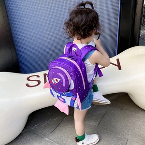 Back view of a girl wearing a purple rocket-shaped backpack with space astronaut design