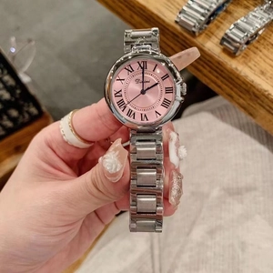 Detailed close-up of a silver watch with a pink dial and black Roman numeral markers