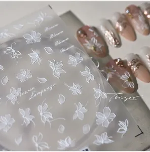 Macro view of 5D white embossed floral nail stickers with elegant petal motifs
