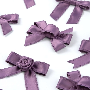 Détail de rubans en soie plissés violets et nœuds de rose faits main avec volants