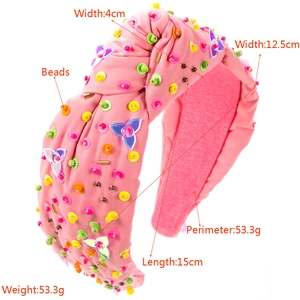 Detail showing pink knotted fabric headband with colorful 3D beads and bright sequins